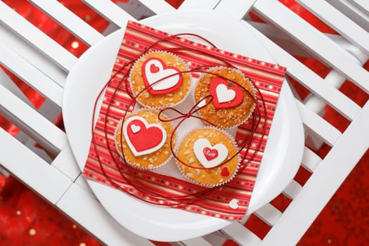 white plate with valentine's day muffins with red and white hearts on a white wooden table