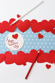 Valentine's day love message, handmade, with pencils and hearts isolated on blue with white dots background (polka dot) with white borders