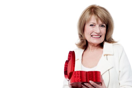 Cheerful woman opening a heart shaped gift box