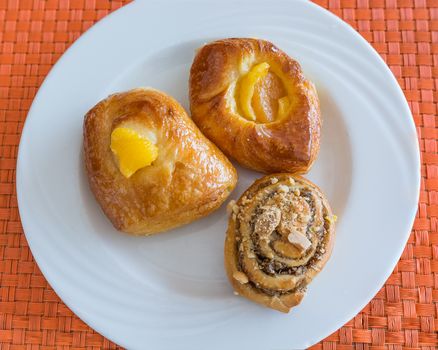 In the pictured three pastries served on a white plate .