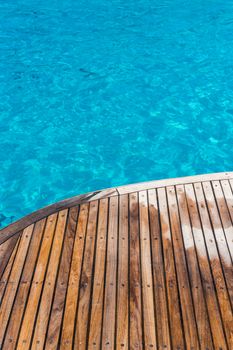 In the pictured curved wooden deck wet and in the background ocean blue / turquoise.