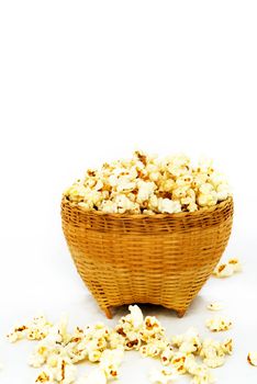 Popcorn in a wooden bucket on white background