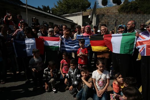 TURKEY, Istanbul: Refugees hold up various European flags as they wait near the Esenler Bus Terminal in Istanbul, Turkey on September 19, 2015 after the government ordered that bus tickets not be sold to them. They are waiting for the government to reverse the decision so they can travel to the Turkish border town of Edirne to continue their journey into Europe