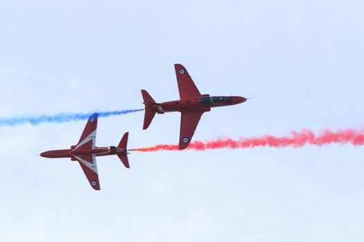 ENGLAND, Southport: Red Arrows fly close to each other in opposite directions while leaving trails of coloured smoke during the Southport Airshow 2015 in Southport, Merseyside in England on September 19, 2015