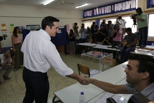 GREECE, Athens: Leader of left-wing party Syriza and former Prime minister Alexis Tsipras shakes hands with an election official at his polling station in Athens on September 20, 2015 during Greek General Election first row. The election is the second Greek General Election within a year.