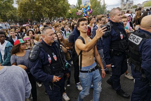 FRANCE, Paris: A partygoer takes a selfie with police officers during the 17th Techno Parade music event in Paris on September 19, 2015.