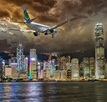 Airplane over Hong Kong skyscrapers.