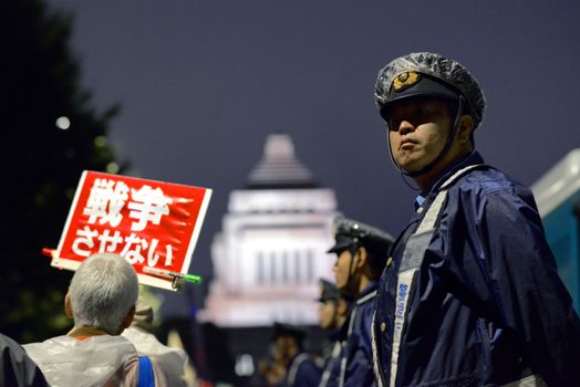 JAPAN, Tokyo: A police officer is seen near Japanese parliament in Tokyo, Japan, on September 17, 2015 during a demonstration against security law. Demonstrators claim Japanese Prime minister Shinzo Abe's resignation.