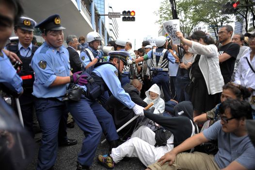 JAPAN, Yokohama: A police officer pulls a protestor during a die-in in Yokohama, Japan, on September 16, 2015 during a demonstration against security law. Demonstrators claim Japanese Prime minister Shinzo Abe's resignation.