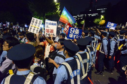 JAPAN, Tokyo: Police officers contain protestors near Japanese parliament in Tokyo, Japan, on September 15, 2015 during a demonstration against security law. Demonstrators claim Japanese Prime minister Shinzo Abe's resignation.