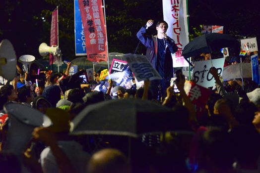 JAPAN, Tokyo: A protestor speaks into a microphone near Japanese parliament in Tokyo, Japan, on September 17, 2015 during a demonstration against security law. Demonstrators claim Japanese Prime minister Shinzo Abe's resignation.
