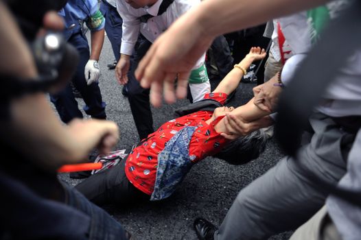 JAPAN, Yokohama: A police officer pulls a protestor during a die-in in Yokohama, Japan, on September 16, 2015 during a demonstration against security law. Demonstrators claim Japanese Prime minister Shinzo Abe's resignation.
