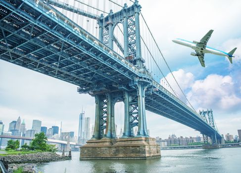 Airplane overflying New York and Manhattan Bridge.