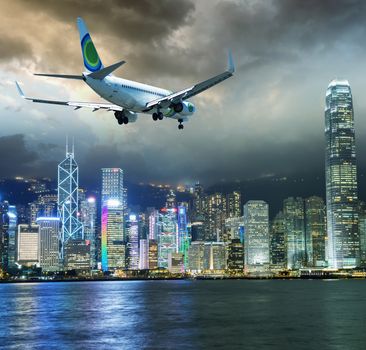 Airplane over Hong Kong skyscrapers.