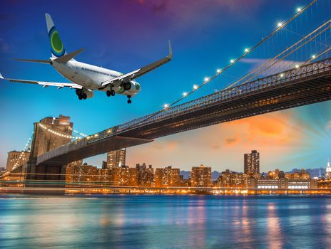 Airplane overflying Brooklyn Bridge in New York City.