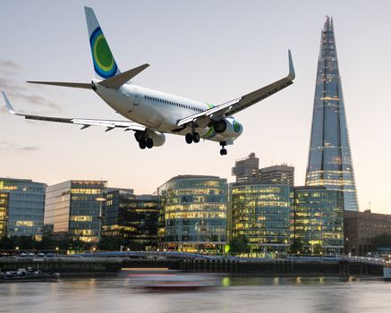 Airplane overflying London - Tourism and vacation concept.