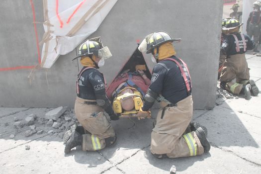 MEXICO, Mexico City: Firefighters simulate a rescue mission on Constitution Square in Mexico City on September 19, 2015 as part of the animations to commemorate 1985's earthquake.