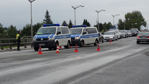 AUSTRIA, Saalachbruecke: Hundreds of migrants wait in cold and rainy weather at the border in Austria hoping to cross into the town of Freilassing in Germany on September 20, 2015.  Many migrants are seeking asylum in either Germany or Sweden, but those countries are calling on their EU partners to show solidarity and share the responsibility. 	