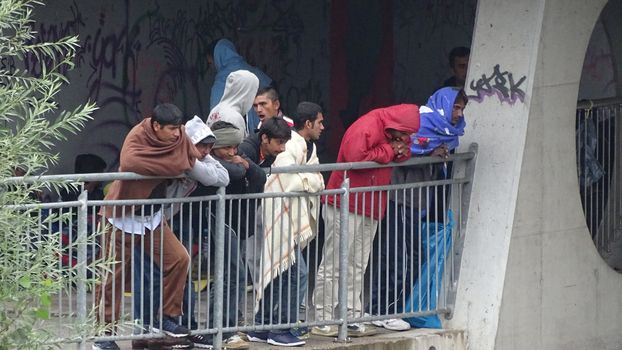 AUSTRIA, Saalachbruecke: Hundreds of migrants wait in cold and rainy weather at the border in Austria hoping to cross into the town of Freilassing in Germany on September 20, 2015.  Many migrants are seeking asylum in either Germany or Sweden, but those countries are calling on their EU partners to show solidarity and share the responsibility. 	