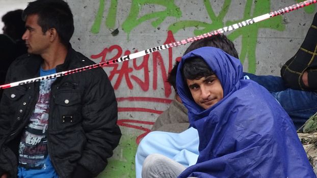 AUSTRIA, Saalachbruecke: Hundreds of migrants wait in cold and rainy weather at the border in Austria hoping to cross into the town of Freilassing in Germany on September 20, 2015.  Many migrants are seeking asylum in either Germany or Sweden, but those countries are calling on their EU partners to show solidarity and share the responsibility. 	