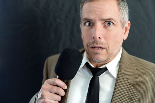 Close-up of an anxious man speaking into microphone.