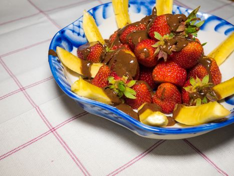 Banana and strawberry under hot chodolate on traditional russian plate - gzhel