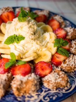Chocolate dessert with banana, strawberry and mint under whipped cream