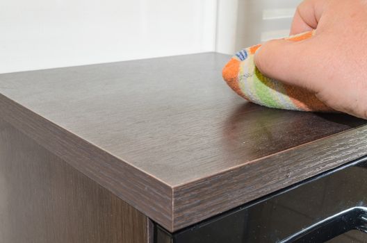 Wipe the dust. Duster in one hand.