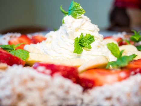 Chocolate dessert with banana, strawberry and mint under whipped cream