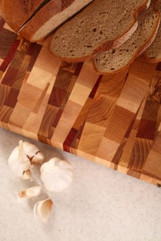 Bread cut on a chopping board and garlic segments