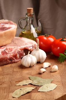 pork, vegetables and bay leaf on a chopping board