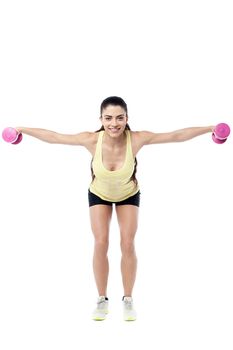 Fitness woman working out hard with dumbbells