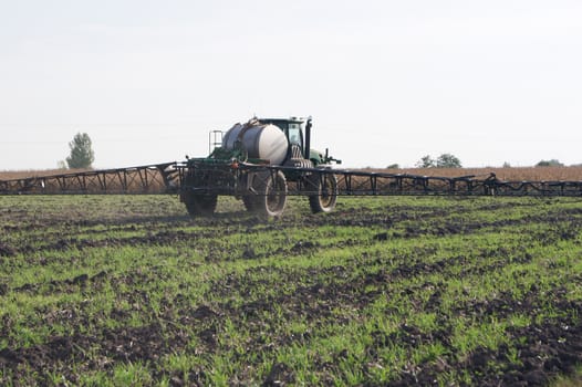 The sprayer tractor working on a big field.