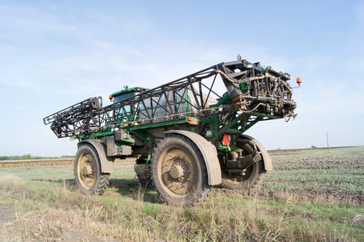 The sprayer tractor working on a big field.