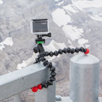 LES DIABLERETS, SWITZERLAND - JULY 22, 2015: Closeup of GoPro Hero 4 camera on GorillaPod tripod in action, filming fast moving clouds.