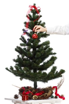 Decorating christmas tree with balls, ribbons and stuff, isolated on white background