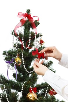 Decorating christmas tree with balls, ribbons and stuff, isolated on white background