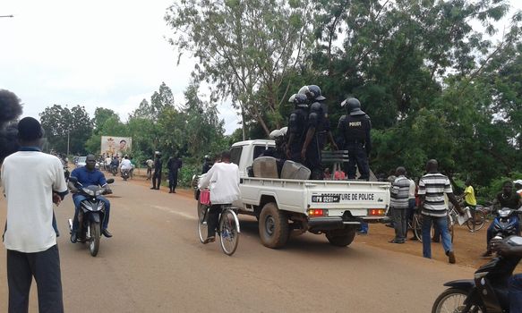 BURKINA Faso, Ouagadougou : Riot policemen watch the street in Ouagadougou, on September 18, 2015, two days after a military coup on September 16, by General Gilbert Diendere, an aide to ousted president Blaise Compaore and members of Compaore's powerful Presidential Security Regiment (RSP) burst into the cabinet meeting room snatching the country's interim president Michel Kafando and Prime Minister Isaac Zida, and two ministers (Augustin Loada and Rene Bagoro). Compaore was toppled October 2014 and fled into exile in Ivory Coast after a popular uprising triggered by his attempt to extend his 27-year rule. 