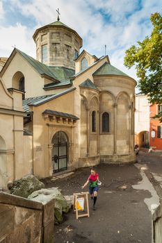 Woman punching at control point, taking part in orienteering city race competitions in old european city