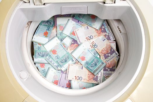 Money laundering concept with Ringgit Malaysia notes in washing machine.