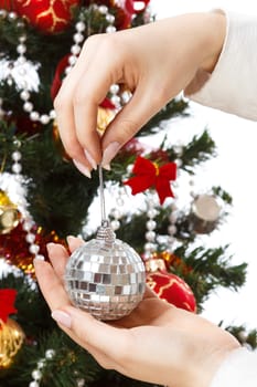 Decorating christmas tree with balls, ribbons and stuff, isolated on white background