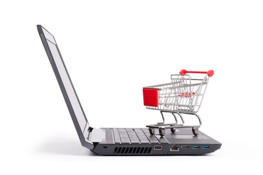 Shopping cart on laptop on isolated white background, close up view