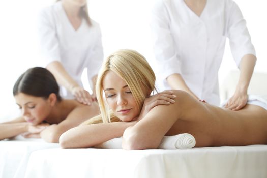 Two beautiful women getting massage in spa