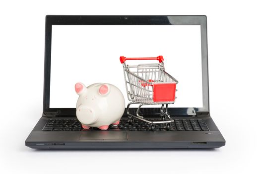 Shopping cart and piggy bank on laptop on isolated white background, front view