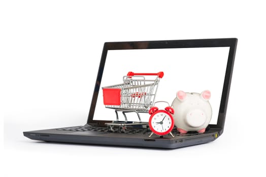 Shopping cart, clock and piggy bank on laptop on isolated white background, front view