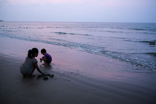 MALAYSIA, Kuala Terengganu:  Two young children play on the beach in Kuala Terengganu, Malaysia on September 21, 2015. Haze covered Malaysia for several days, but cleared on Monday morning. The country suffers from poor air quality and the haze often blankets the region. Malaysia and neighboring countries are trying to figure out a way to combat the haze which causes problems in the area.