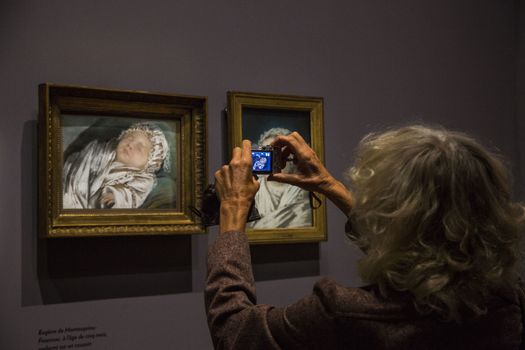 FRANCE, Paris: A woman takes a photo of a portrait of a baby painted by �lisabeth Louise Vig�e Le Brun in Le Grand Palais, in Paris on September 21, 2015. �lisabeth Louise Vig�e Le Brun (1755-1842) is one of the greater portrait painter of her time. She was chosen to paint the very famous queen of France Marie-Antoinette. 