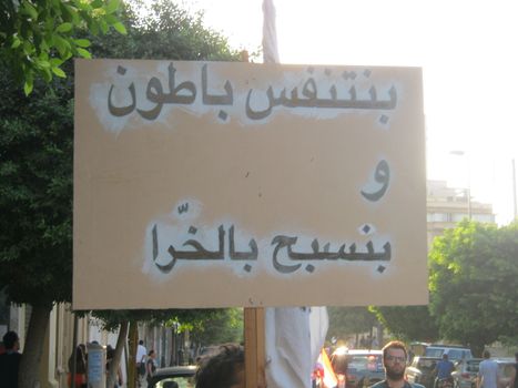 LEBANON, Beirut: A protester carries a sign reading We breathe in bottles and we swim in crap and trash in Beirut on September 21, 2015 as part of the #YouStink movement rallying against alleged government corruption.