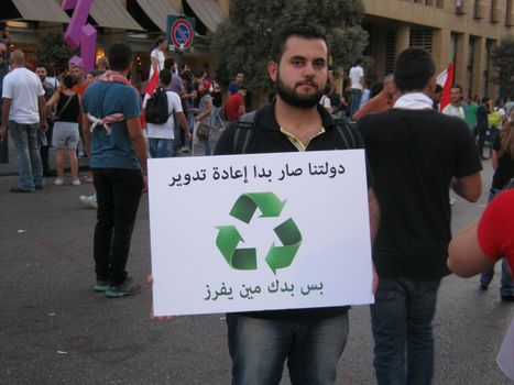 LEBANON, Beirut: A protester carries a sign reading Our government needs to be recycled too, but who is going to do it? in Beirut on September 21, 2015 as part of the #YouStink movement rallying against alleged government corruption.