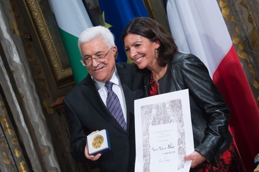 FRANCE, Paris : Palestinian Authority president Mahmoud Abbas (L) poses next to Paris' mayor Anne Hidalgo after receiving the medal of Paris during a ceremony marking the International Day of Peace on September 21, 2015 at Paris' city hall. 